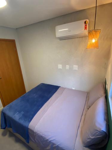 a small bedroom with a bed with a blue blanket at Casa de Dora in São Miguel dos Milagres