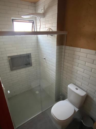 a bathroom with a toilet and a glass shower at Casa de Dora in São Miguel dos Milagres