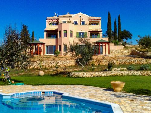 una grande casa con piscina di fronte a una casa di Mouse House a Gouviá