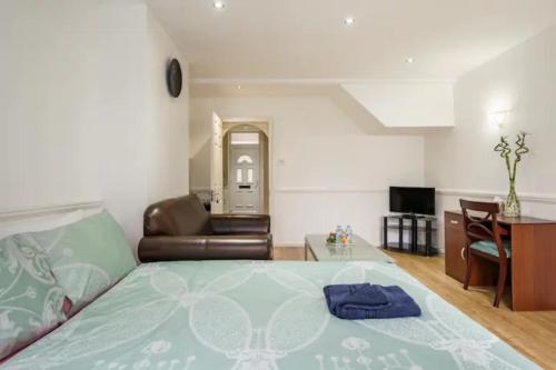 ein Schlafzimmer mit einem Bett, einem Sofa und einem Tisch in der Unterkunft Eltar Hostle in London