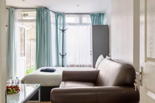 ein Wohnzimmer mit einem Sofa und einem Bett in der Unterkunft Eltar Hostle in London