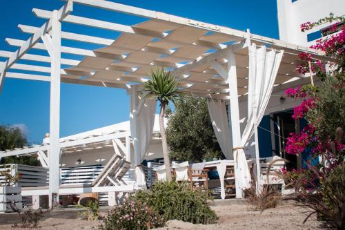 a white pergola in front of a building at Arcana Santorini Villas, An Authentic Cycladic Experience in Akrotiri