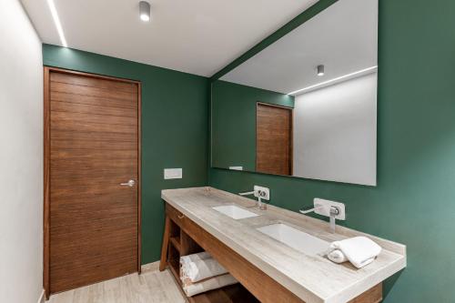 uma casa de banho com um lavatório e um espelho em 308-303 Beautiful apartments with 3 bedrooms em Tulum