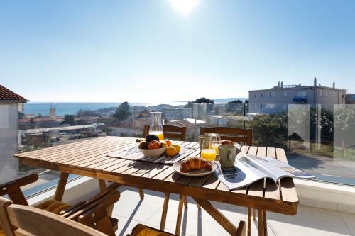 a wooden table with food on top of a balcony at Apartment Klara in Krk