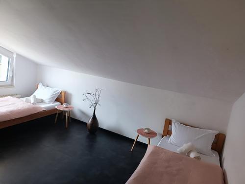 a bedroom with two beds and a vase on the wall at Apartma FRIGO in Maribor