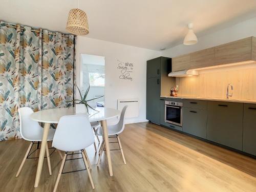 une cuisine et une salle à manger avec une table et des chaises dans l'établissement Maison cosy au calme parking privé inclus, à Carquefou