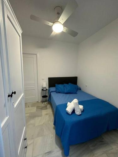 1 dormitorio con 2 camas con sábanas azules y techo en Moderno apartamento junto al mar- Apartamentos Don Diego, en Torremolinos