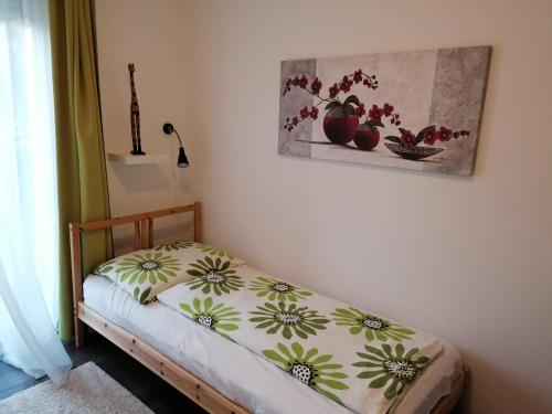 - un petit lit dans une chambre ornée d'une peinture murale dans l'établissement Zamárdi apartman, à Zamárdi