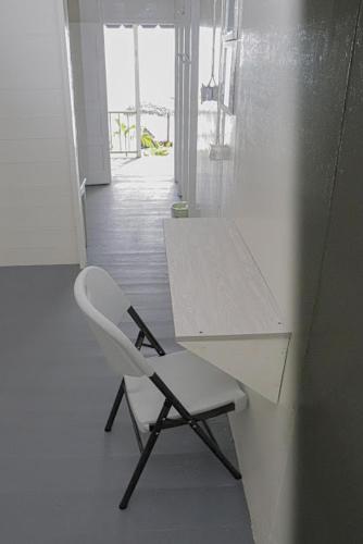 a white chair sitting next to a desk in a room at Little Bay Hideaway in Little Bay