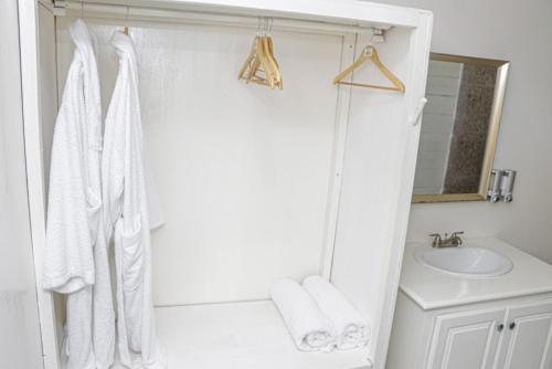 a white bathroom with a shower and a sink at Little Bay Hideaway in Little Bay