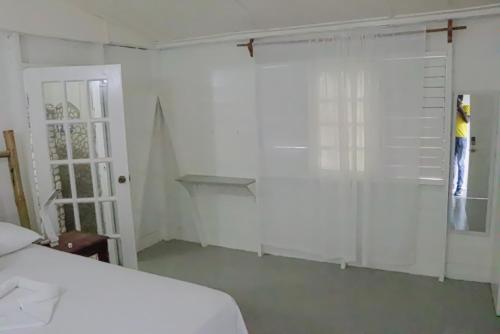 a bedroom with a bed and a door and a window at Little Bay Hideaway in Little Bay
