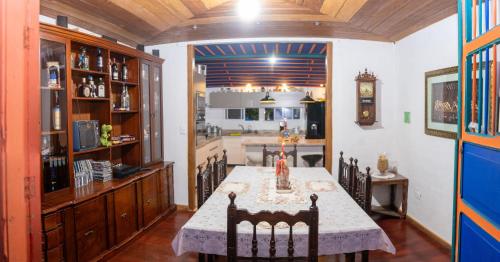 a dining room with a table and a kitchen at Misiá Emilia, Café - Hostal in Apía