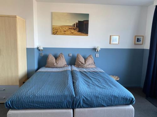 a blue bedroom with a bed with blue sheets at Bed&Breakfast aan Strand in Katwijk aan Zee