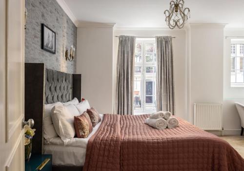 ein Schlafzimmer mit einem Bett mit einem ausgestopften Tier darauf in der Unterkunft Park Street Mayfair apartments in London