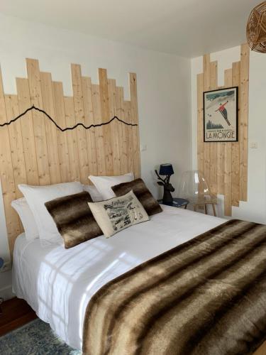 sypialnia z dużym łóżkiem z drewnianym zagłówkiem w obiekcie La Bigourdane w mieście Gerde