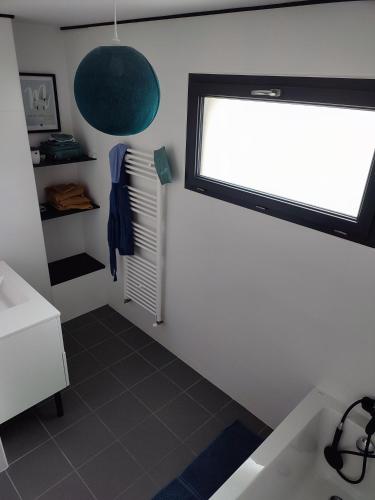 La salle de bains est pourvue d'un lavabo et d'une fenêtre. dans l'établissement Calm property - Le Mans 24h / GP France / Classic, à Changé