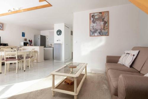 un salon avec un canapé et une table dans l'établissement Charmant duplex à 500 m du port d'hyeres LESCLESDENICOLE LE PRADET, à Hyères
