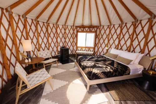 a bedroom in a yurt with a bed and a table at Frontier Drive Inn in Center