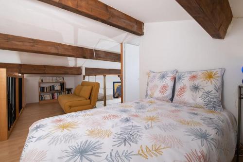 une chambre avec un lit et une chaise dans l'établissement Charmant duplex à 500 m du port d'hyeres LESCLESDENICOLE LE PRADET, à Hyères