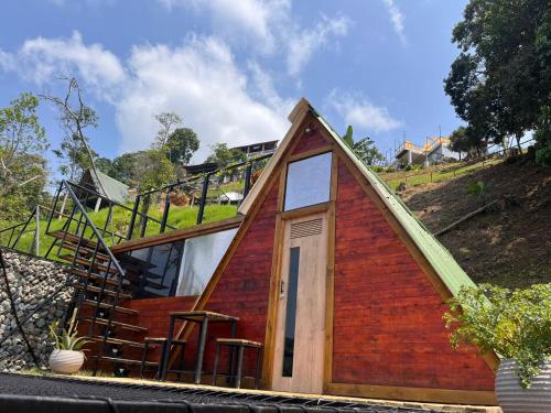 una pequeña casa con techo y escalera en Entre Verdes Hotel & Glamping, en Medellín