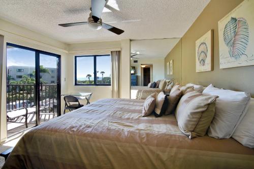 - une chambre avec un grand lit et un balcon dans l'établissement Land's End 1-301 Gulf View - Premier, à St. Pete Beach