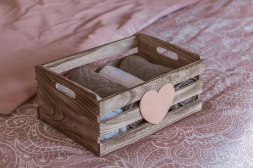 a wooden box with towels and a heart on a bed at Apartman Ponte Martini in Punat
