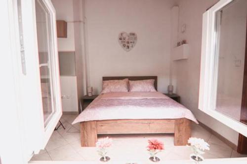 a bedroom with a bed and two windows at Apartman Ponte Martini in Punat