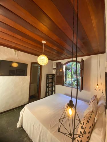 a bedroom with a large bed with a wooden ceiling at pousada vida de Búzios recanto in Búzios
