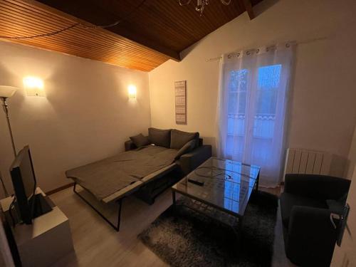 ein Wohnzimmer mit einem Sofa und einem Glastisch in der Unterkunft Gîte campagnart 
