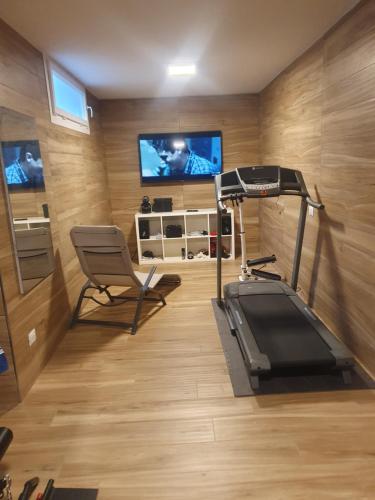 un gimnasio con cinta de correr y TV en una habitación en Villa Mariel Lago Maggiore luxury Suite & Wellness en Gravellona Toce