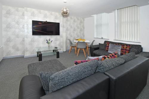 a living room with a couch and a table at Smithfield Apartments - Gated Executive City Centre Apartments in Stoke on Trent