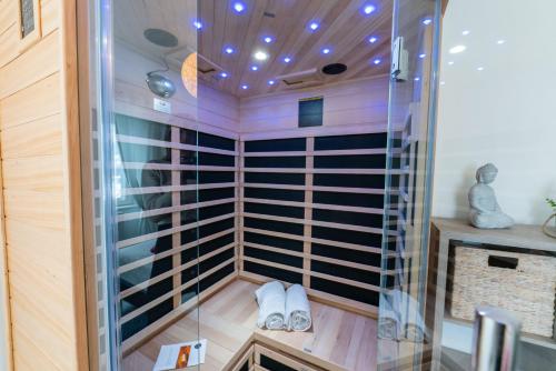 a sauna with glass walls and a wooden floor at Gîte l'Améthyste 3 appartements in Gérardmer