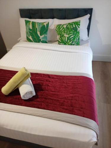 Una cama con una manta roja y blanca. en Dayrooms, en Norbury