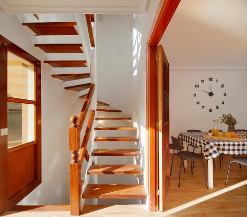 a wooden staircase in a room with a table at 158A Triplex Rinconin con piscina in Gijón