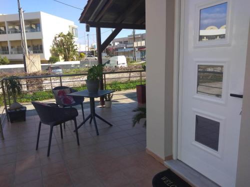 a patio with a table and chairs and an umbrella at Cozy Home (close to the beach) in Nea Kydonia