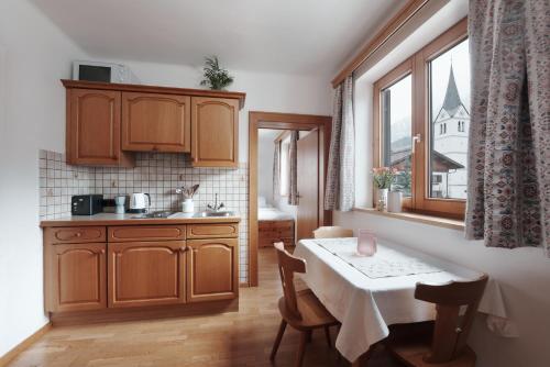 une cuisine avec une table et une petite cuisine avec une fenêtre dans l'établissement Appartement Leni Leogang, à Leogang