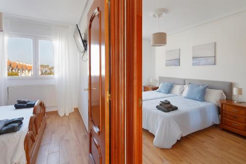 a bedroom with two beds and a window at 158A Triplex Rinconin con piscina in Gijón