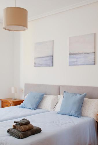 a bedroom with a bed with a towel on it at 158A Triplex Rinconin con piscina in Gijón
