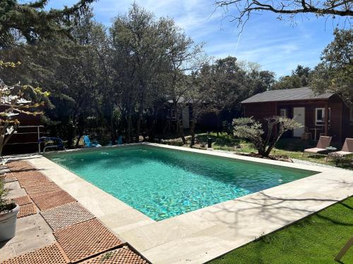 a swimming pool in the yard of a house at Casa Rural de Rafael Cabañas de Madera in Venturada