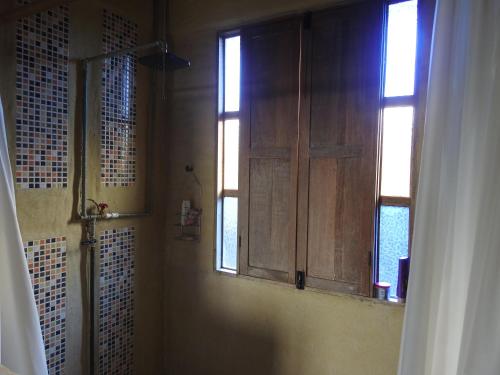 baño con puerta de madera y ventana en Mágica Casa en el Campo - Ícono de La Cumbre, en La Cumbre