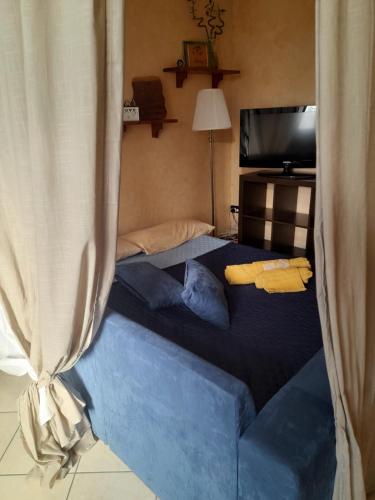 una camera da letto con un grande letto blu con tende di B&B Picchio a Madonna di Fornelli