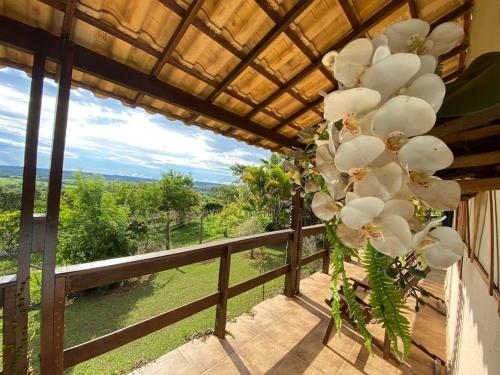 a bunch of white flowers on a balcony with a view at Casa da Vista - LAGOA SANTA in Lagoa Santa
