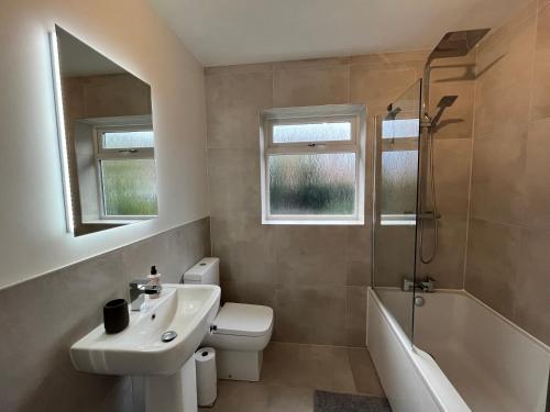 W łazience znajduje się umywalka, toaleta i prysznic. w obiekcie Stunning Beverley Bungalow w Fireplace, private parking, and garden w mieście Beverley