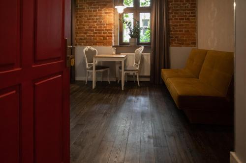 een woonkamer met een tafel en stoelen en een bank bij Apartament Atłasowy by Good Time in Łódź
