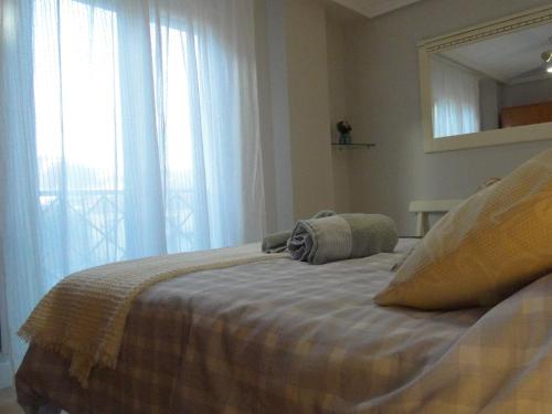 a bedroom with a bed with a mirror and a window at INSULA PLAzA MAYOR HOME in Astorga