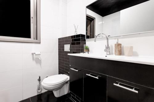 ein weißes Bad mit einem WC und einem Waschbecken in der Unterkunft One Step from the Sea. Apartment 5 +parking. in Tel Aviv