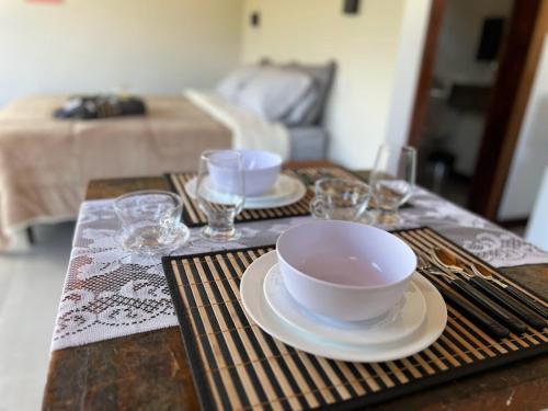 uma mesa com dois pratos e tigelas e copos sobre ela em Chalé Lírio do Campo em Ouro Preto