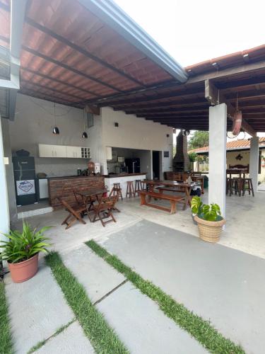 a patio with wooden tables and chairs and a grill at Abrolhos Dive Inn in Caravellas