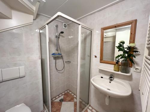 a bathroom with a shower and a sink at Gelijkvloers Vakantieappartement 150m van Strand Egmond aan Zee in Egmond aan Zee