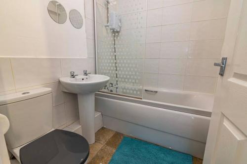 a bathroom with a sink and a toilet and a bath tub at Bright and Spacious Apartments in Eastwood